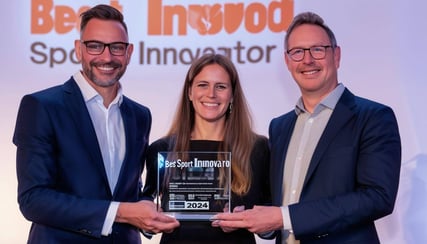 Two men and a women in business suits accepting a glass award that says Best Sport Innovator 2024